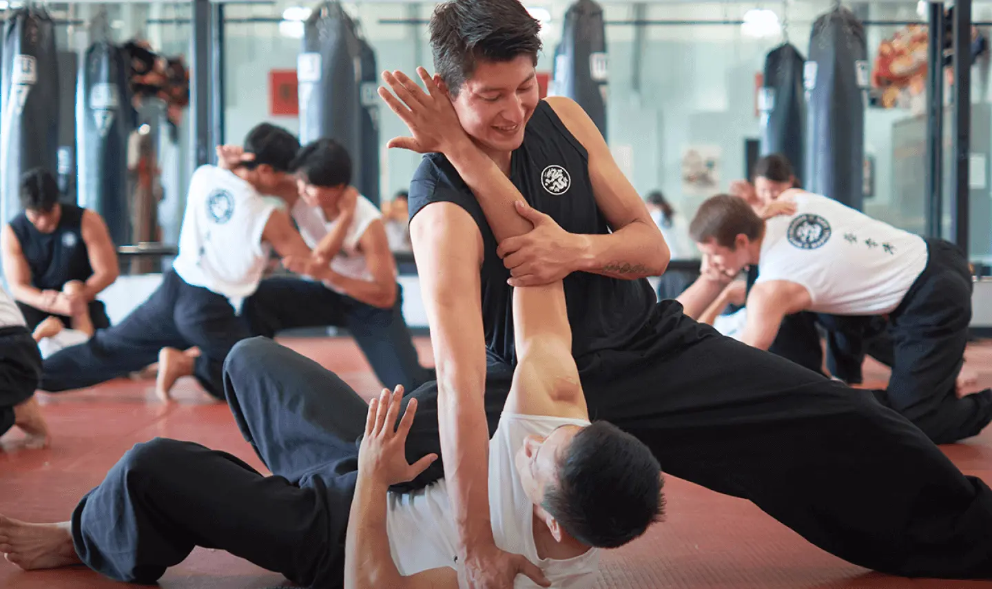 Adult Students Working on Ground Fighting Techniques During a Grappling Class
